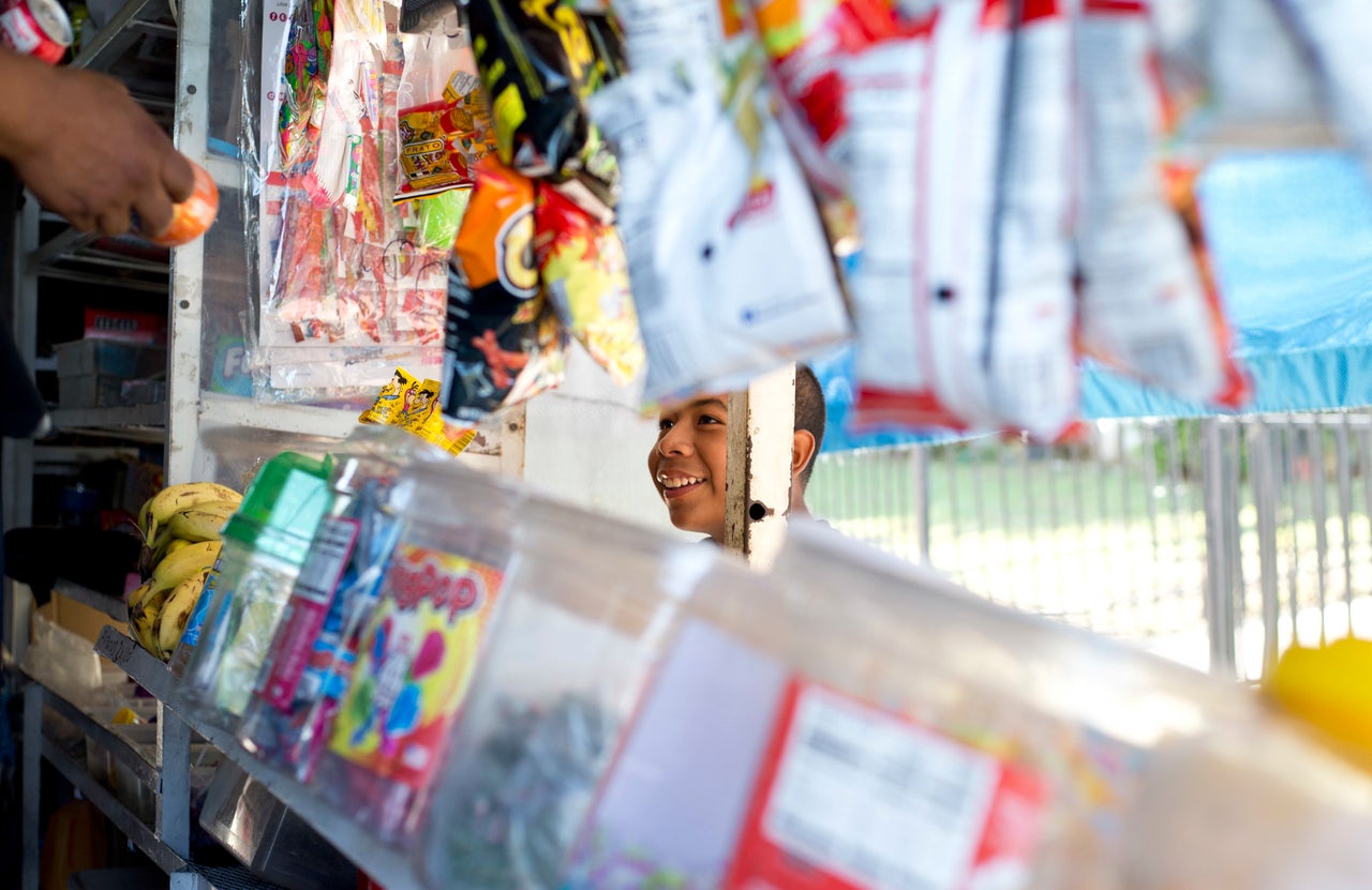 Cesar buys water and soda from the truck vendor parked outside his Townsend Street apartment complex in Santa Ana.