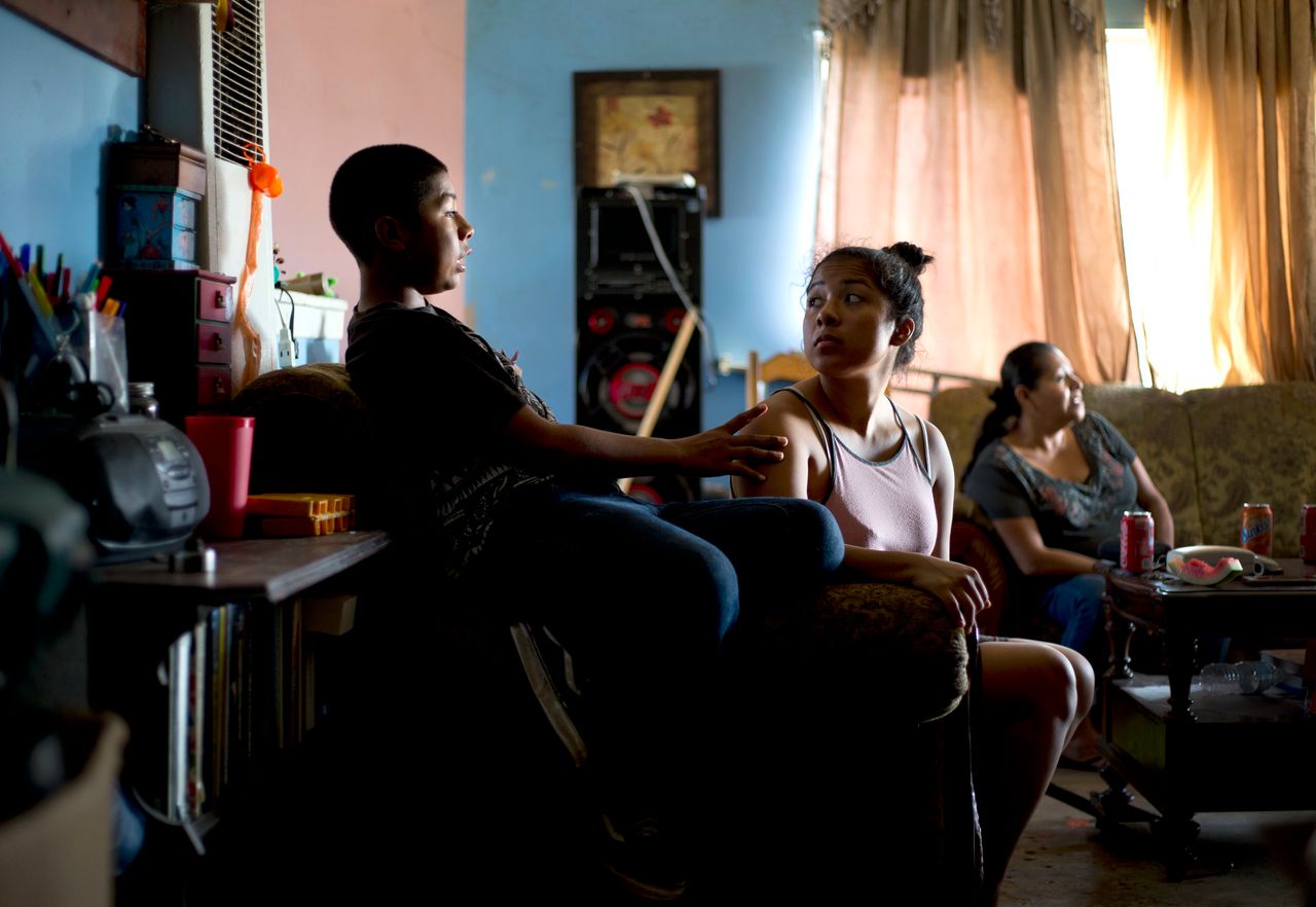 Cesar (left) with his sister Nadia, 18, and mother, Kenia (right), in the living room of their Townsend Street apartment in Santa Ana. Nadia was hospitalized for severe lead poisoning as a 2-year-old while living on the same street in a different apartment complex.