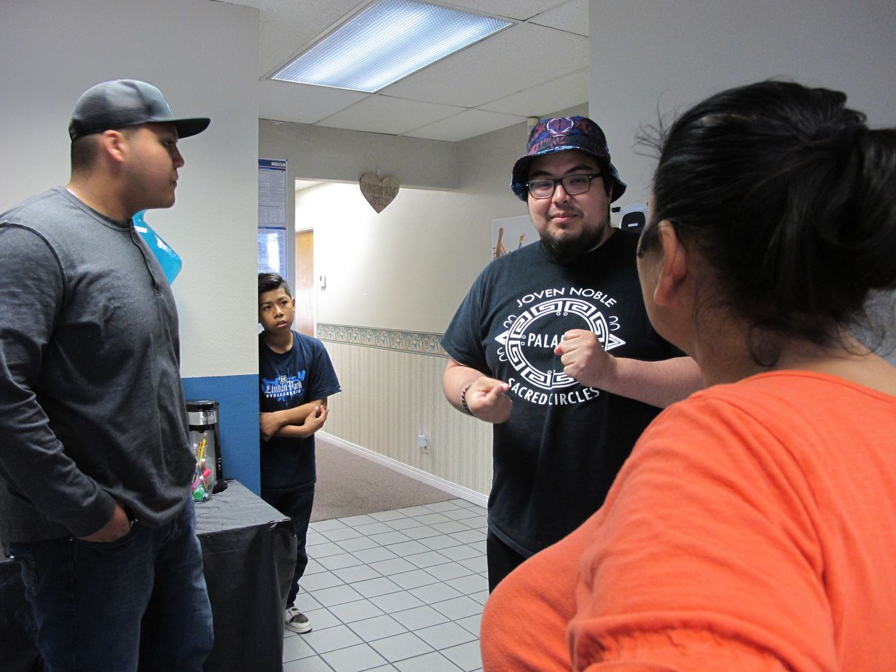 Ramon Campos (center right), a youth organizer with Resilience Orange County, talks to Cesar's mother after she drops off her son for a mentoring session in April 2018.