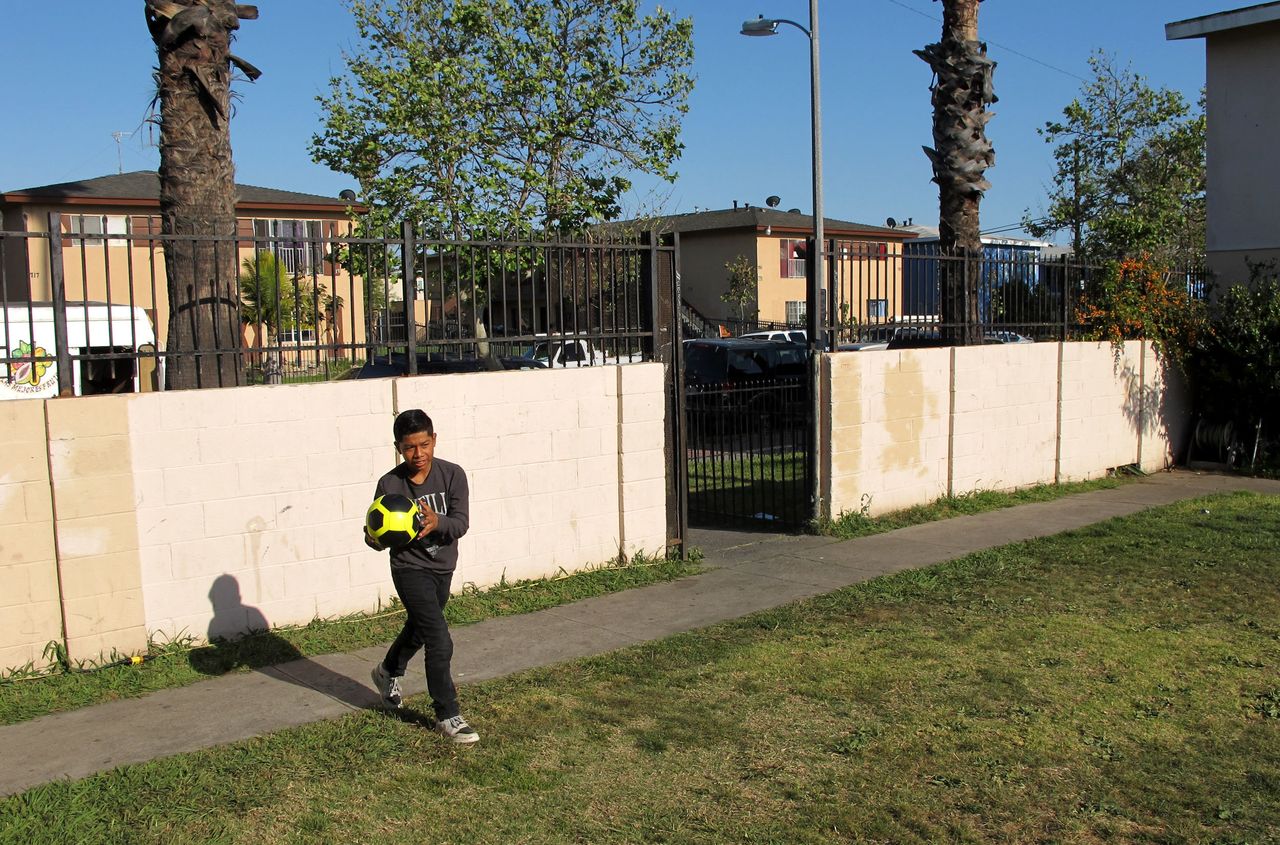 Cesar, 12, plays soccer with his younger brother, Peter (not pictured), in the yard of their Santa Ana apartment complex in April 2018.