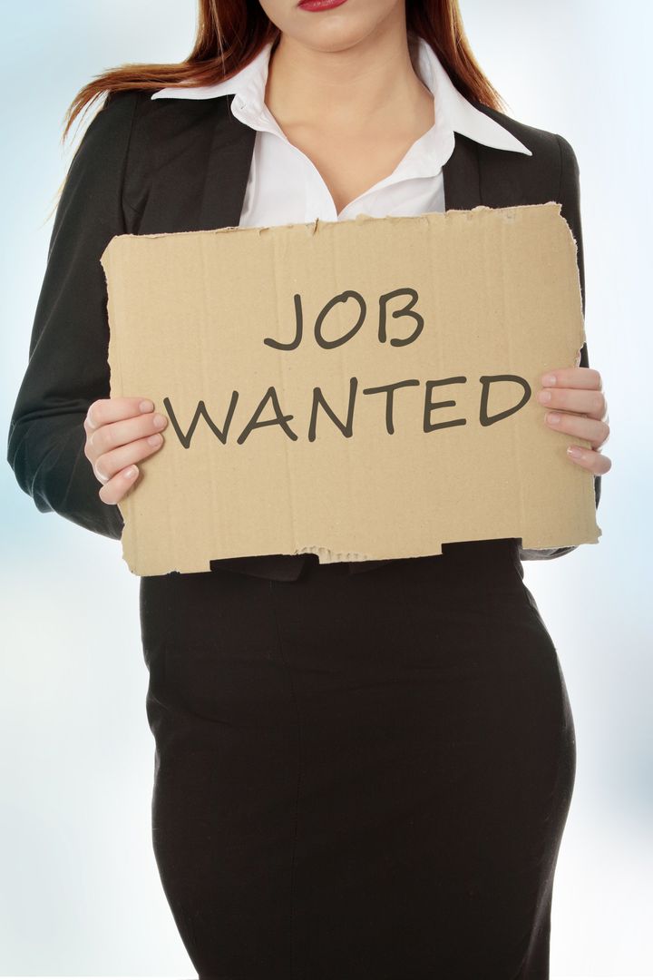 Unemployed businesswoman with cardboard sign - job wanted.