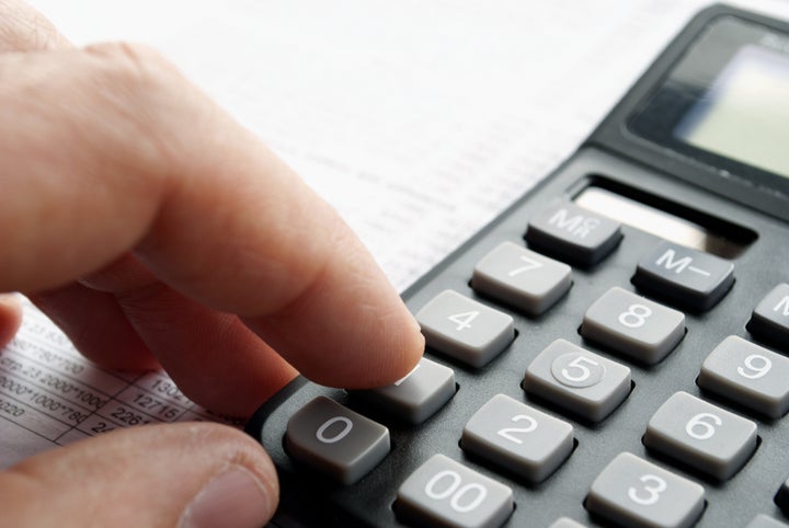 man's hand and a calculator