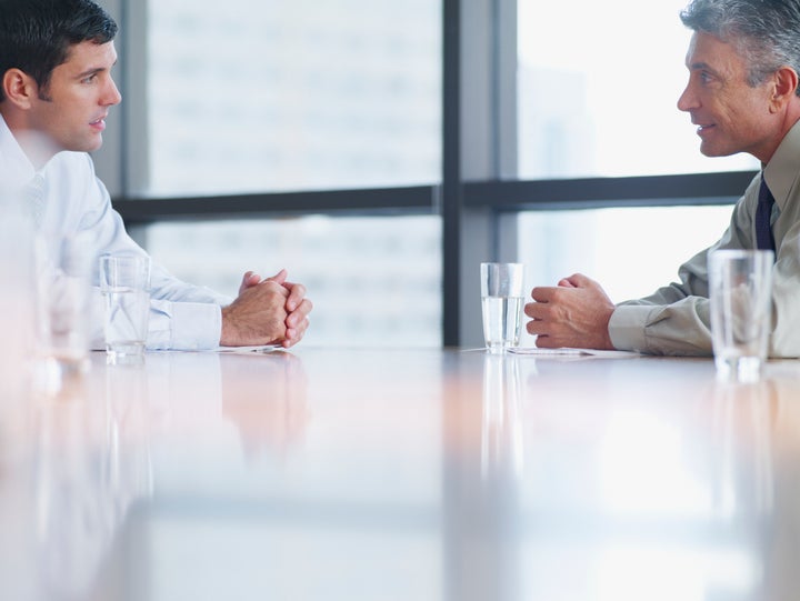 Two businessmen in boardroom with paperwork