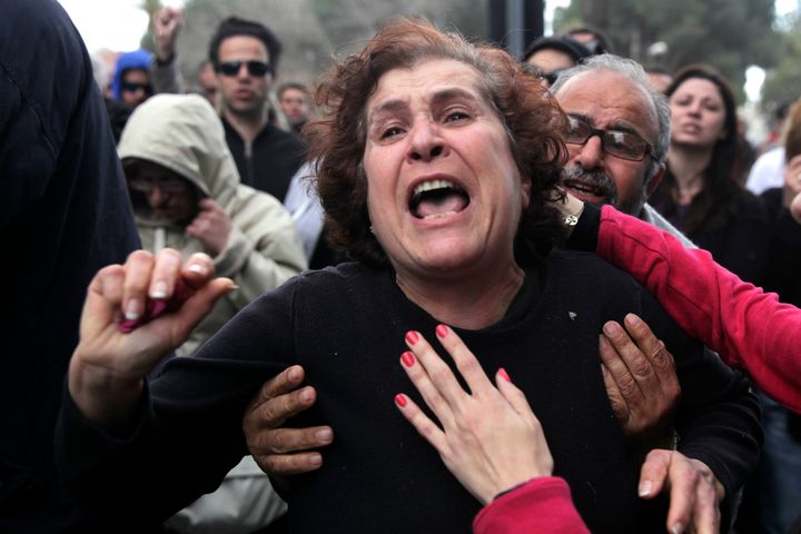 A Cypriot woman gets emotional during a protest outside the parliament building in the capital Nicosia on March 22, 2013. Cyprus' two biggest lenders urged lawmakers to adopt a tax on bank deposits, a controversial deal with the EU that the MPs rejected this week, as their employees protested outside parliament. AFP PHOTO/YIANNIS KOURTOGLOU (Photo credit should read Yiannis Kourtoglou/AFP/Getty Images)