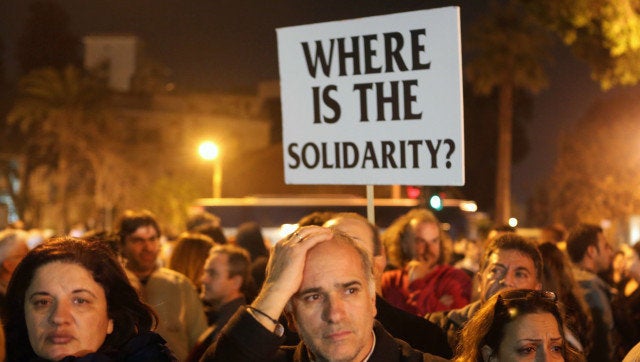 Cypriot empoyees of the Laiki (Popular) Bank take part in a protest outside the Parliament on March 21, 2013 in Nicosia. The