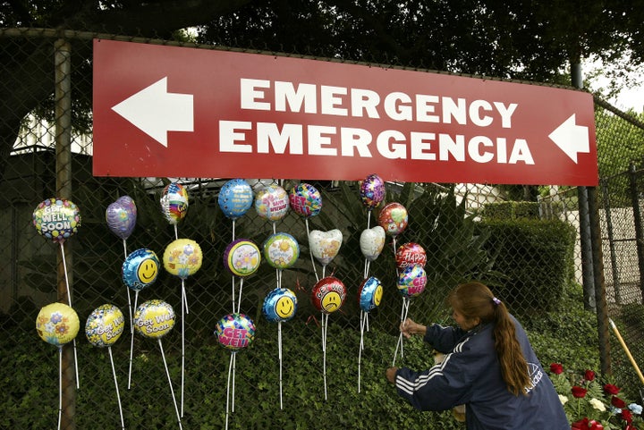 LOS ANGELES - MAY 17: A Mexican immigrant arranges 'get well' balloons she is selling under a sign pointing to the emergency