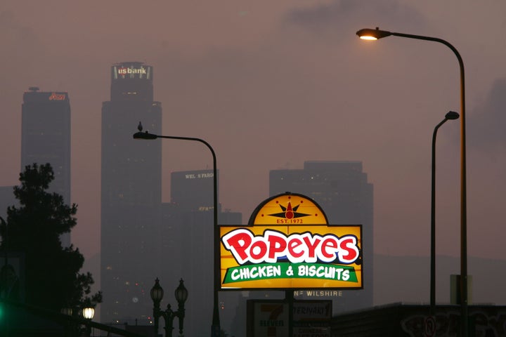 LOS ANGELES, CA - JULY 24: A Popeyes fast-food restaurant sign glows above the city skyline on July 24, 2008 located in the Figueroa Corridor area of South Los Angeles, Los Angeles, California. The Los Angeles City Council committee has unanimously approved year-long moratorium on new fast-food restaurants in a 32-square-mile area, mostly in South Los Angeles, pending approval by the full council and the signature of Mayor Antonio Villaraigosa to make it the law. South LA has the highest concentration of fast-food restaurants of the city, about 400, and only a few grocery stores. L.A. Councilwoman Jan Perry proposed the measure to try to reduce health problems associated with a diet high in fast-food, like obesity and diabetes, which plague many of the half-million people living there. (Photo by David McNew/Getty Images)