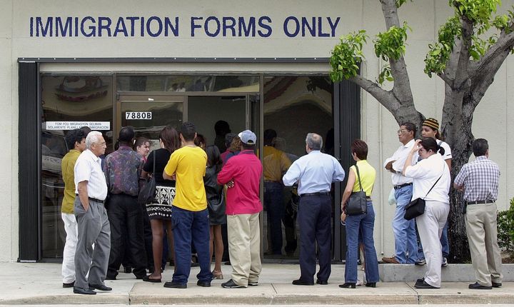 MIAMI, : A line forms near the entrance of the Immigration and Naturalization Service office in Miami, 30 April 2001, as the midnight deadline approaches for illegal immigrants to apply for visas. The Legal Immigration and Family Equity Act allows illegal immigrants nationwide to apply for visas without having to return to their home countries and apply from there. AFP PHOTO/RHONA WISE (Photo credit should read RHONA WISE/AFP/Getty Images)