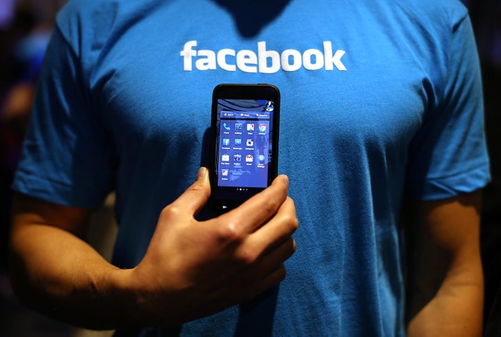 MENLO PARK, CA - APRIL 04: A Facebook employee holds a phone that is running the new 'Home' program during an event at Facebook headquarters during an event at Facebook headquarters on April 4, 2013 in Menlo Park, California. Facebook CEO Mark Zuckerberg announced a new product for Android called Facebook Home as well as the new HTC First phone that will feature the new software. (Photo by Justin Sullivan/Getty Images)