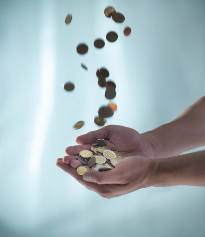 Close up of hands catching pile of coins