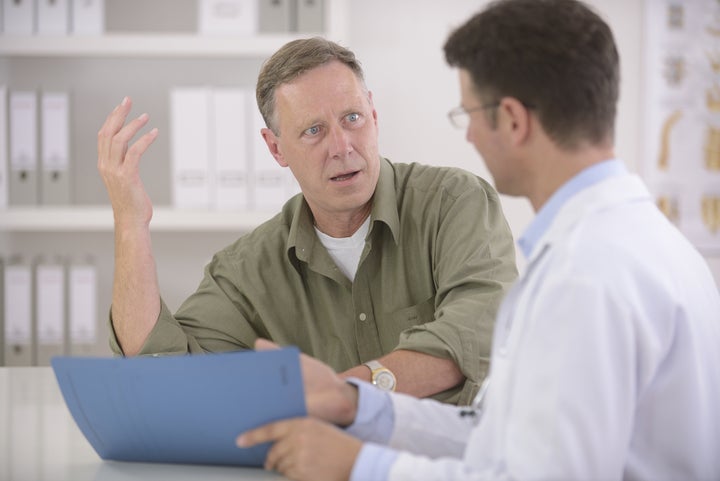 Doctor talking to mature male patient