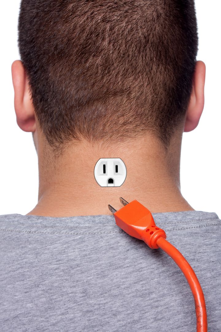 Conceptual image of a young man with an electrical socket on the back of his neck with the power plug disconnected.