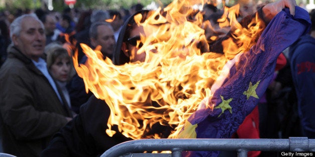 A demonstrator burns a European Union flag outside the parliament in the Cypriot capital, Nicosia, on April 4, 2013, followin
