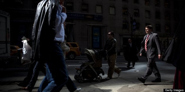 NEW YORK - APRIL 9: Suits walk by the more causally dressed on the streets of Midtown Manhattan, home to many of the world's banks on April 9, 2009 in New York City. (Photo by Jeff Hutchens/Edit by Getty Images)