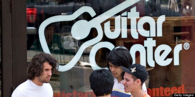 UNITED STATES - JUNE 27: Guitar Center employee Josh Weinhaus, back to camera, talks with customers Chris Villano, left, Pau