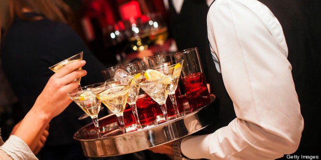 Waiter holding a tray full with Martini coctails