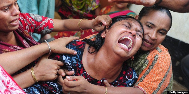 Relatives react after identifying the body of a loved one killed in last week's building collapse in Savar, on the outskirts of Dhaka, on May 3, 2013. The death toll from last week's collapse of a garment factory complex in Bangladesh passed 500 Friday as the country's prime minister said Western retailers had to share some of the blame for the tragedy. AFP PHOTO/Munir uz ZAMAN (Photo credit should read MUNIR UZ ZAMAN/AFP/Getty Images)