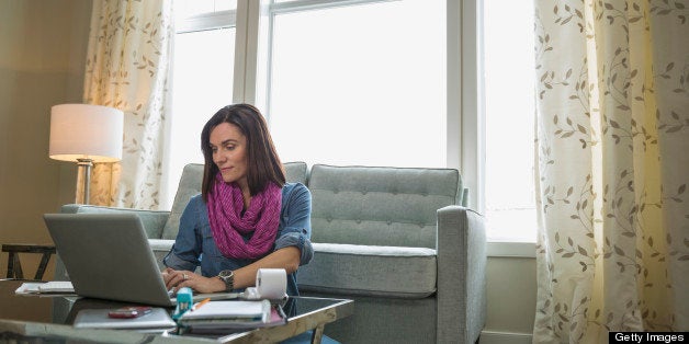 Mature woman working on laptop at coffee table