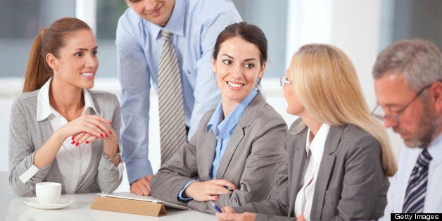 Group of business people sitting at table and having conversation.