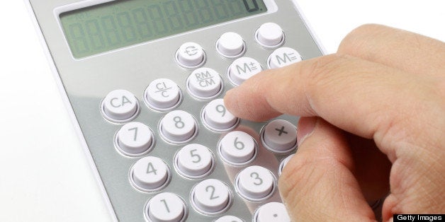 Close-up of a hand pushing on calculator.