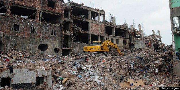 Excavators clear debris as Bangladeshi rescue and army personnel continue recovery operations at the site of the eight-storey