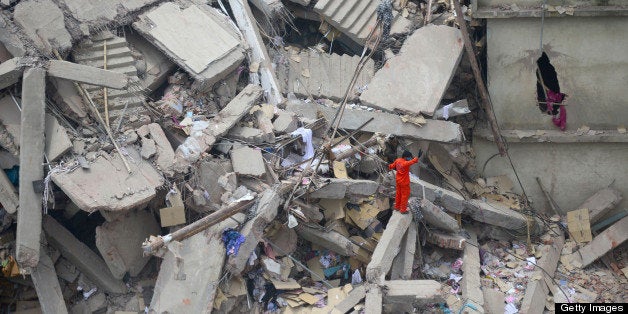 A Bangladeshi volunteer stands amid rubble as he assists in rescue operations after an eight-storey building collapsed in Savar, on the outskirts of Dhaka, on April 25, 2013. Survivors cried out to rescuers April 25 from the rubble of a block of garment factories in Bangladesh that collapsed killing 175 people, sparking criticism of their Western clients. AFP PHOTO/Munir uz ZAMAN (Photo credit should read MUNIR UZ ZAMAN/AFP/Getty Images)