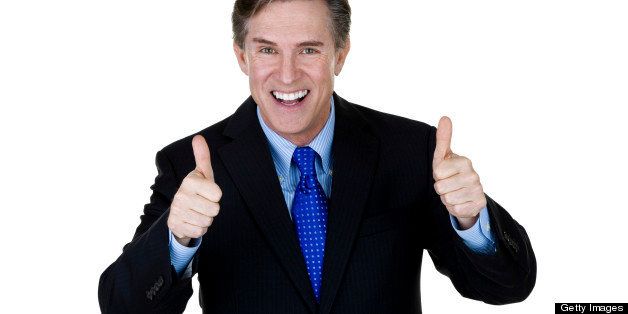 Horizontal composition of a mature businessman gesturing thumbs up and smiling 
