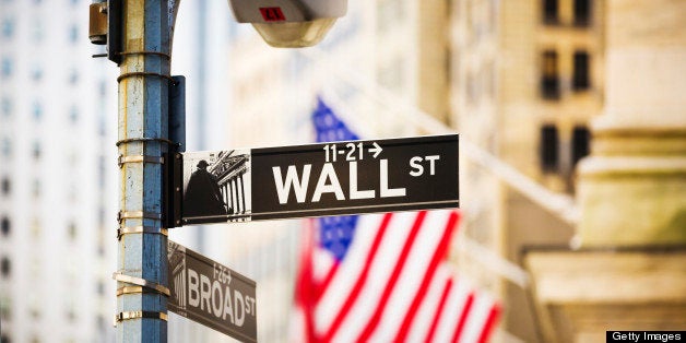 Wall Street sign against New York Stock Exchange, New York City, USA.