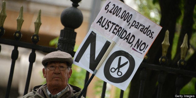 A demonstrator holds a banner reading '6.200.000, unemployed. Austerity, no!', a reference to the latest jobless figure in Spain, during a Labour Day protest against the Spanish government's austerity policies in the centre of Madrid on May 1, 2013. AFP PHOTO / DOMINIQUE FAGET (Photo credit should read DOMINIQUE FAGET/AFP/Getty Images)