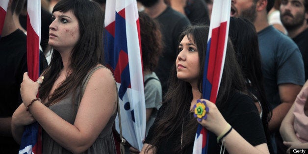 Communist affilited youth chant slogans while participating in the PAME (Panergatiko Agonistiko Metopo or All-Workers Militant Front) union rally at Syntagma Square in central Athens on July 11, 2013. Greece's main unions will hold a general strike on July 16 to oppose a new round of civil service job cuts announced by the government to secure EU-IMF loans. Affecting thousands of teachers, school wardens and municipal staff, the latest cuts have caused fresh outrage in a country undergoing a fourth year of austerity and record unemployment. AFP PHOTO/ LOUISA GOULIAMAKI (Photo credit should read LOUISA GOULIAMAKI/AFP/Getty Images)