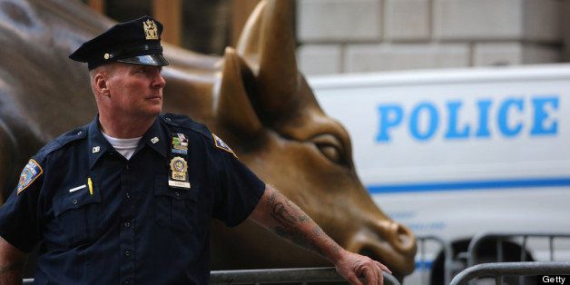NEW YORK, NY - SEPTEMBER 17: A police officer stands guard at the Wall Street Bull on the one-year anniversary of the Occupy Wall Street movement on September 17, 2012 in New York City. Occupy protesters converged on the city's financial district to demonstrate what they say is an unfair economic system befefiting corporations and the wealthy instead of ordinary citizens. (Photo by John Moore/Getty Images)