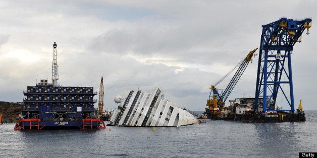 GLIO PORTO, ITALY - JANUARY 14: The sunken Costa Concordia remains in the water the day after the commemoration for the victims on January 14, 2013 in Giglio Porto, Italy. It is now a year after the sinking of the ship Costa Concordia. More than four thousand people were on board when the ship hit a rock off the Tuscan coast, killing 32 and leaving two people missing. (Photo by Laura Lezza/Getty Images)