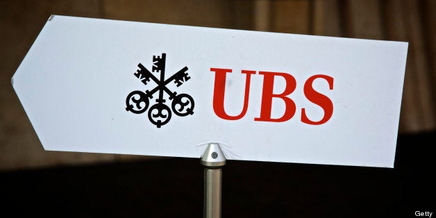 The UBS AG logo sits on a sign outside the bank's offices in Basel, Switzerland, on Tuesday, July 23, 2013. Europe's biggest