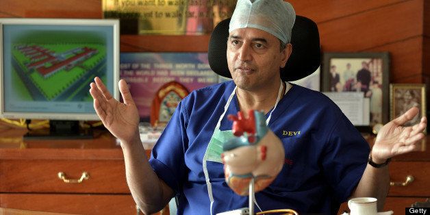 TO GO WITH India-health-hospital,FEATURE by Adam Plowright In this picture taken on February 7, 2013 Indian philanthropist, cardiac surgeon and founder of Narayana Hrudayalaya,Devi Prasad Shetty gestures during an interview at the cardiac-care hospital in Bangalore. What if hospitals were run like a mix of Wal-Mart and a low-cost airline? The result might be something like the chain of 'no-frills' Narayana Hrudayalaya clinics in southern India. Using pre-fabricated buildings, stripping out air-conditioning and even training visitors to help with post-operative care, the group believes it can cut the cost of heart surgery to an astonishing 800 USD. AFP PHOTO/Manjunath KIRAN (Photo credit should read Manjunath Kiran/AFP/Getty Images)