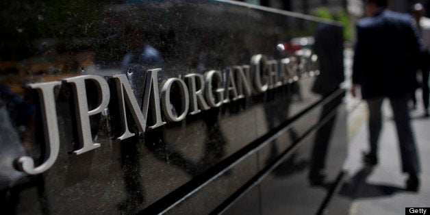 Pedestrians walk by the offices of JPMorgan Chase & Co. in New York, U.S., on Friday, May 17, 2013. As JPMorgan Chase & Co.?s