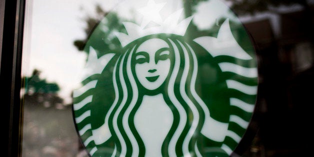 The Starbucks Corp. logo is displayed in the window of a store in Toronto, Ontario, Canada, on Tuesday, July 23, 2013. Starbu