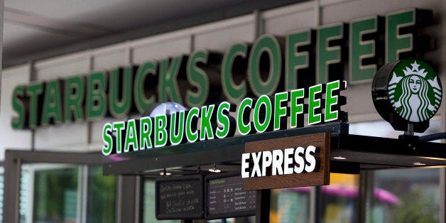 Logos stand above a counter outside a Starbucks Corp. coffee shop in Berlin, Germany, on Tuesday, May 28, 2013. Starbucks, the world's biggest coffee-shop operator, reported fiscal second-quarter profit in April that met analysts' estimates as U.S. customer traffic improved while sales stagnated in Europe. Photographer: Krisztian Bocsi/Bloomberg via Getty Images