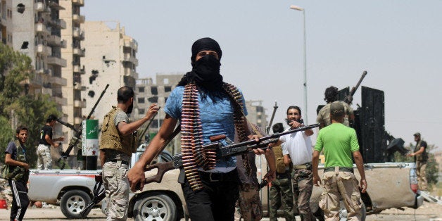 Syrian rebels fighting pro-regime forces gather along a road in Syria's eastern town of Deir Ezzor, on August 17, 2013. Al-Qaeda loyalists attacked a mainly Kurdish town in northeastern Syria sparking fighting in which 17 people were killed, two of them ambulance crew, a watchdog said. AFP PHOTO/ABO SHUJA (Photo credit should read ABO SHUJA/AFP/Getty Images)