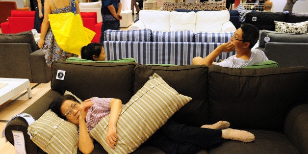 An elderly Chinese (bottom) women rests on a sofa as people shop at an Ikea frurniture store in Beijing on August 15, 2011. Asia, including China and India, will be vulnerable if the US and Europe slip into another recession, Singapore Prime Minister Lee Hsien Loong said in his annual policy speech, Lee warned it was possible the world would sink into another recession because of the debt crisis in Europe and the United States' economic woes that led to a landmark downgrade by Standard & Poor's of the country's top-notch credit ratings. AFP PHOTO / Mark RALSTON (Photo credit should read MARK RALSTON/AFP/Getty Images)