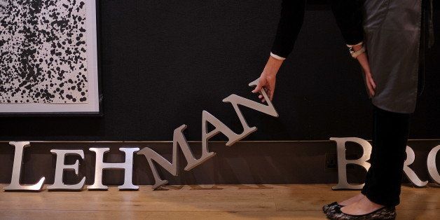 An employee poses for photographers with part of a Lehman Brothers company sign at Christie's auction house in London on September 24, 2010. The sign will be sold as part of the 'Lehman Brothers: Artwork and Ephemera' sale in London on September 29. AFP PHOTO / BEN STANSALL (Photo credit should read BEN STANSALL/AFP/Getty Images)