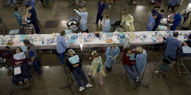 KNOXVILLE, TN - JANUARY 31: Patients lined up for dental treatment in the dental care area at the makeshift hospital with almost assembly-line precision. 904 teeth will be pulled here in two days on January 31, 2009 in Knoxville, Tennessee. Thousands of uninsured and underinsured Americans are treated every year for free in makeshift field hospitals operated by the Remote Area Medical Volunteer Corps. A small army of volunteer health-care professionals offers medical attention to patients who are not likely to see another doctor or dentist all year. The clinics saves lives and alleviates suffering, but in the face of a growing national health-care crisis, it may not be enough. (Photo by Jonathan Torgovnik/Edit by Getty Images)