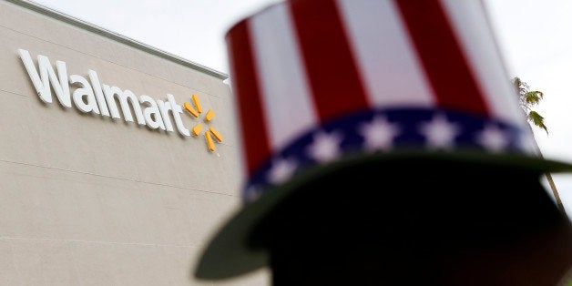 A man wearing a hat decorated with stars and stripes joins protesters during a demonstration outside a Wal-Mart store in Los Angeles, California, U.S., on Tuesday, July 2, 2013. Southern California community supporters joined Wal-Mart Stores Inc. workers to protest against alleged illegal violations of employees labor rights and freedom of speech. Photographer: Patrick T. Fallon/Bloomberg via Getty Images