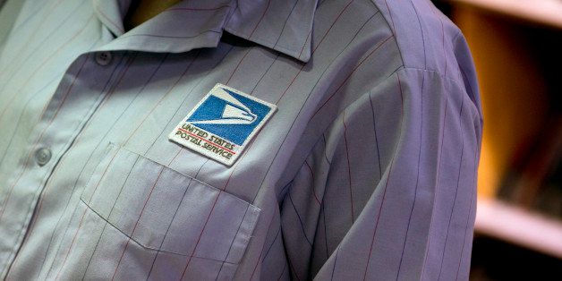 The U.S. Postal Service (USPS) logo is seen on the shirt of a letter carrier at the Brookland Post Office in Washington, D.C., U.S., on Thursday, May 9, 2013. The USPS is projecting a loss of as much as a $6 billion for the year as it keeps pressure on Congress for help, Postmaster General Patrick Donahoe said this month. The service is scheduled to release second-quarter results May 10. Photographer: Andrew Harrer/Bloomberg via Getty Images