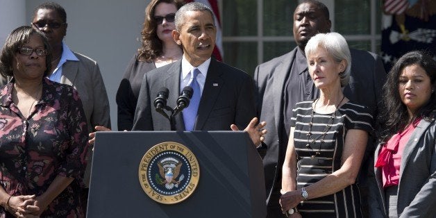 US President Barack Obama speaks alongside Secretary of Health and Human Services Kathleen Sebelius (R) and people who will benefit from health insurance plans under the Affordable Care Act, as well speaks about the government shutdown in the Rose Garden of the White House in Washington, DC, October 1, 2013. AFP PHOTO / Saul LOEB (Photo credit should read SAUL LOEB/AFP/Getty Images)