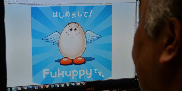 This photo illustration shows a man looking at a computer screen displaying the mascot 'Fukuppy' of Japan's refrigerator maker Fukushima Industries on the company's homepage in Tokyo on October 15, 2013. Japan's Fukushima Industries said on October 15 it was rethinking its 'Fukuppy' mascot, after the Internet erupted in sniggers over a name that recalls the catalogue of mishandling at the Fukushima nuclear plant. AFP PHOTO / Yoshikazu TSUNO (Photo credit should read YOSHIKAZU TSUNO/AFP/Getty Images)