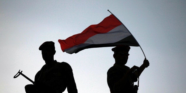 Police troopers are silhouetted as they stand guard on bridge overlooking the parade commemorating the second anniversary of