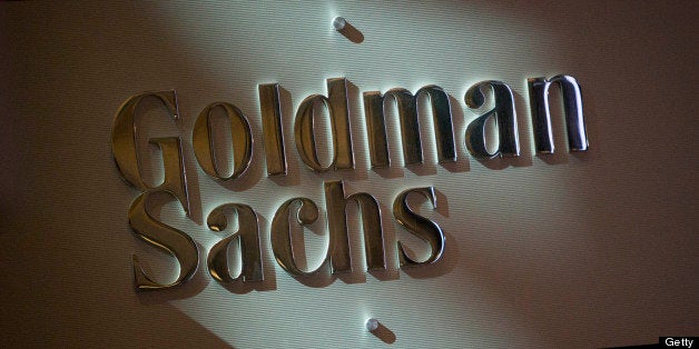 The Goldman Sachs & Co. logo is displayed at the company's booth on the floor of the New York Stock Exchange (NYSE) in New York, U.S., on Friday, July 19, 2013. U.S. stocks fell after benchmark equities gauges rose to records yesterday, after disappointing earnings from Google Inc. and Microsoft Corp. overshadowed better-than-forecast results from General Electric Co. Photographer: Scott Eells/Bloomberg via Getty Images