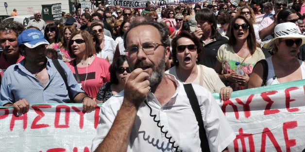 Health workers,doctors and unions chant slogans outside the ministry of health in central Athens on August 23, 2013 protesting cost-cutting changes in the health sector that includes transfers of hospital staff. A third aid package for Greece will be much smaller than the two preceding programmes, German Finance Minister Wolfgang Schaeuble said in a newspaper interview on August 23. AFP PHOTO/ LOUISA GOULIAMAKI (Photo credit should read LOUISA GOULIAMAKI/AFP/Getty Images)