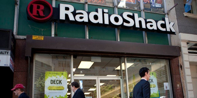 Pedestrians pass in front of a RadioShack Corp. store in New York, U.S., on Thursday, Oct. 24, 2013. RadioShack Corp.'s new financing falls short of what the unprofitable electronics retailer needs to turn itself around after a 'sharp decline' in third-quarter performance, according to debt research firm CreditSights. Photographer: Mati Milstein/Bloomberg via Getty Images