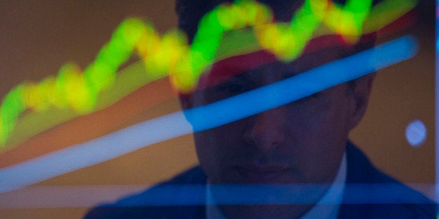 The reflection of a trader working is seen on a monitor on the floor of the New York Stock Exchange (NYSE) in New York, U.S., on Monday, Nov. 18, 2013. Most U.S. stocks fell after the Dow Jones Industrial Average rose above 16,000 for the first time, spurring concern that equity valuations are too high. Photographer: Jin Lee/Bloomberg via Getty Images